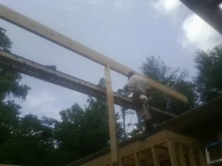Carpenter setting a ridge beam over a new addition frame — Ice Dam Removal by Roofing Brothers in Port Clinton