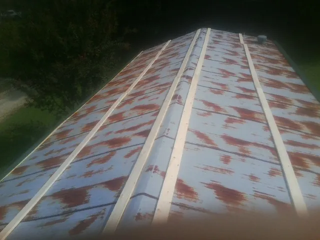 Rusted metal roof panels with new wood purlins before replacement — Storm Damage Roof Repair in Port Clinton by Roofing Brothers