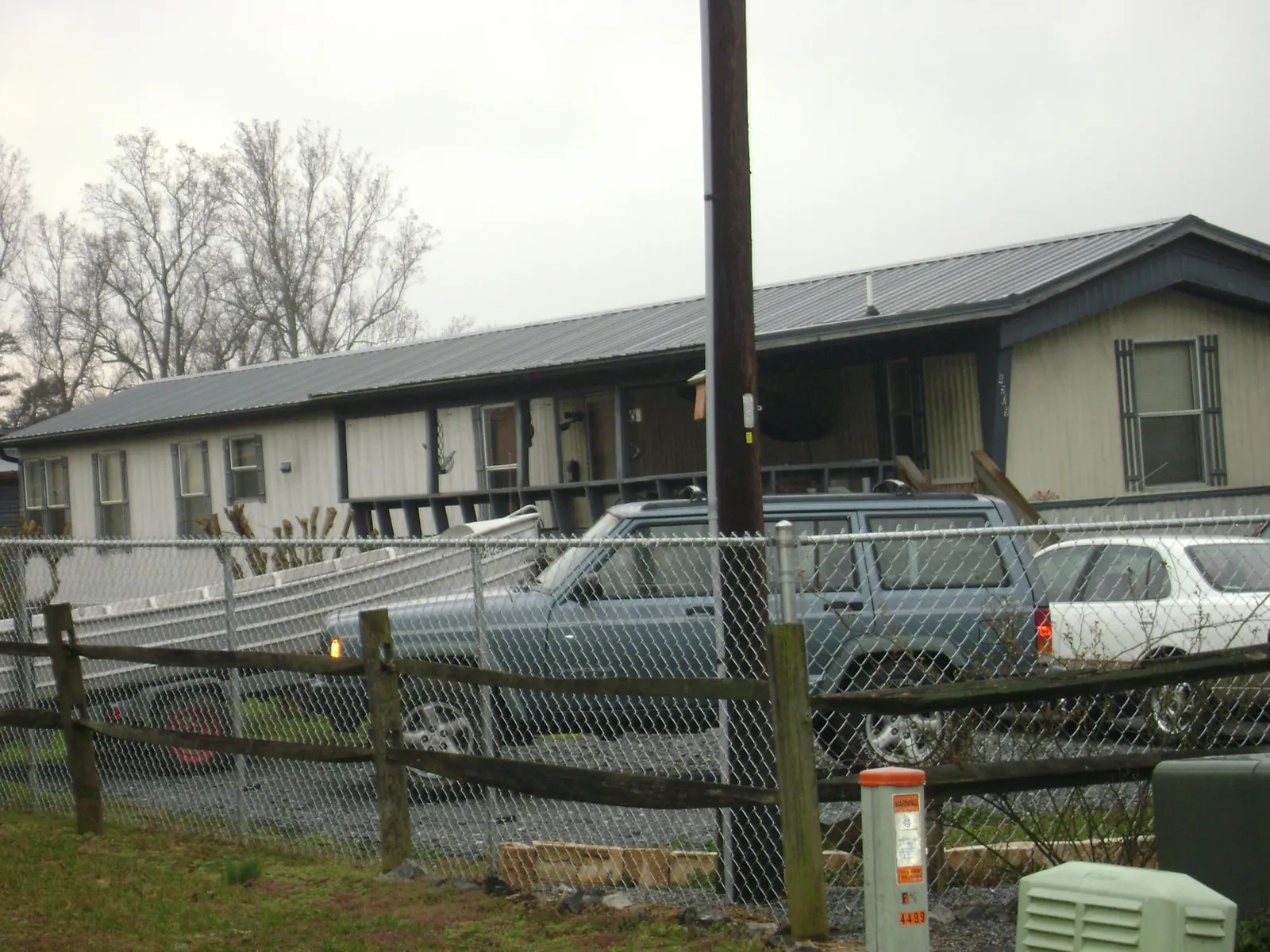 Dark metal roof on a long single story building behind a chain link fence in Port Clinton