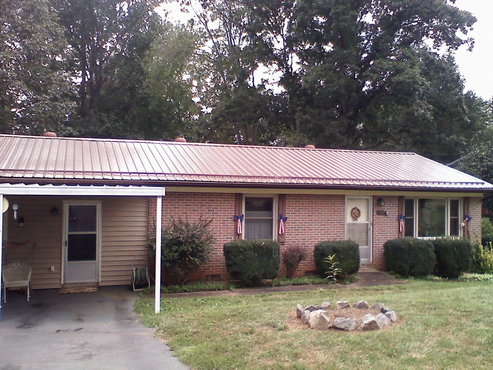 Bronze metal roof and carport on a brick ranch home — Roof Repair work by our crew in Port Clinton