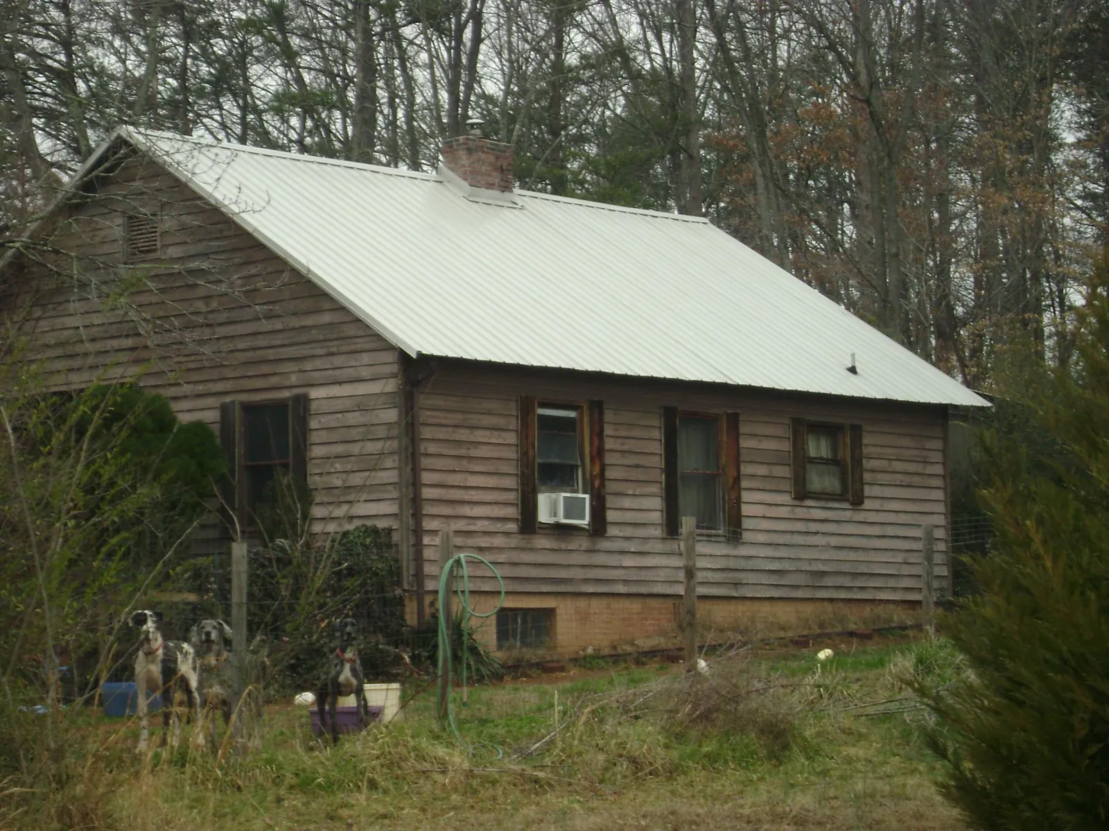 White metal roof on an old wood sided farmhouse, from a Metal Roof Installation job in Port Clinton